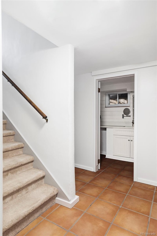 stairway featuring tile patterned floors and baseboards