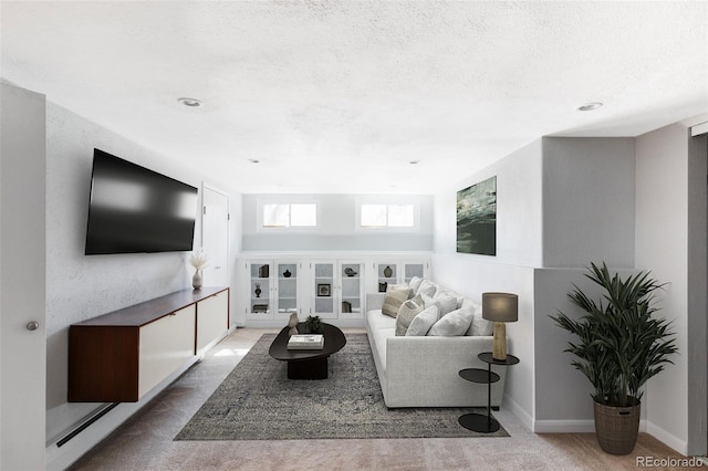 carpeted living area featuring a textured ceiling and baseboards