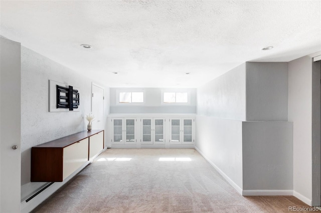 carpeted spare room with baseboards and a textured ceiling