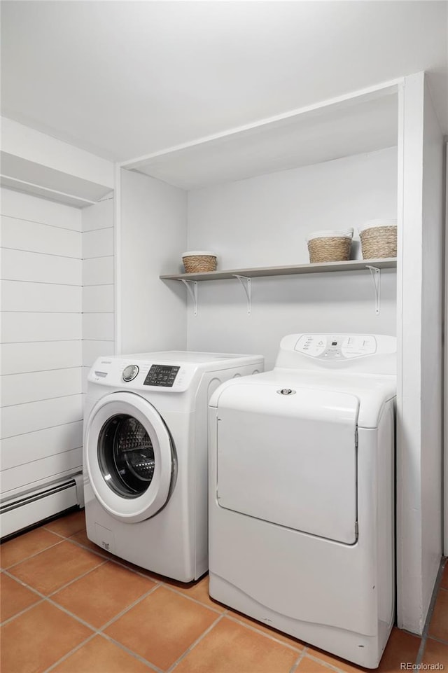 laundry area with light tile patterned floors, baseboard heating, laundry area, and washing machine and clothes dryer