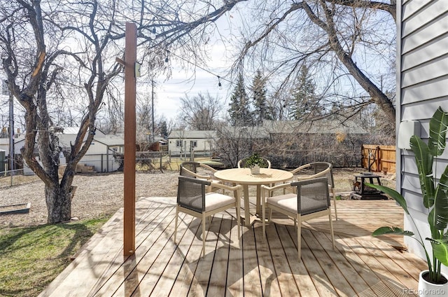 wooden deck featuring outdoor dining area and a fenced backyard