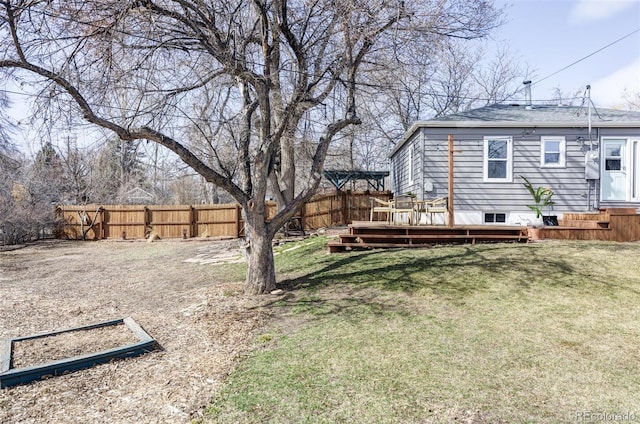 view of yard with a deck, driveway, and fence