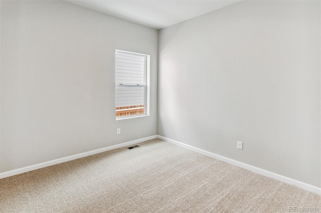 spare room featuring visible vents, light carpet, and baseboards