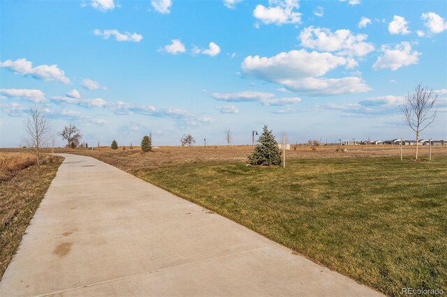 view of community featuring a lawn and a rural view