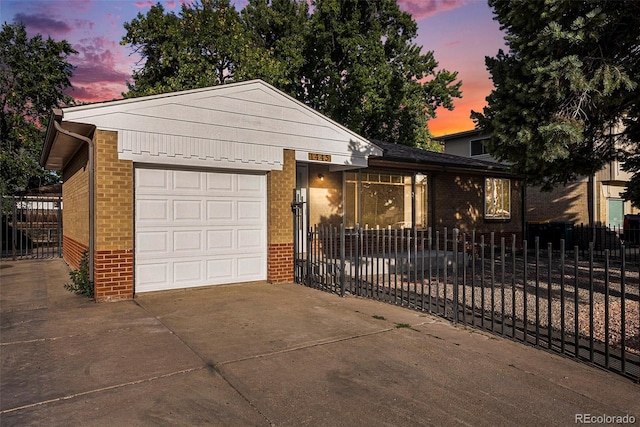 view of front of home with brick siding, concrete driveway, a garage, and fence