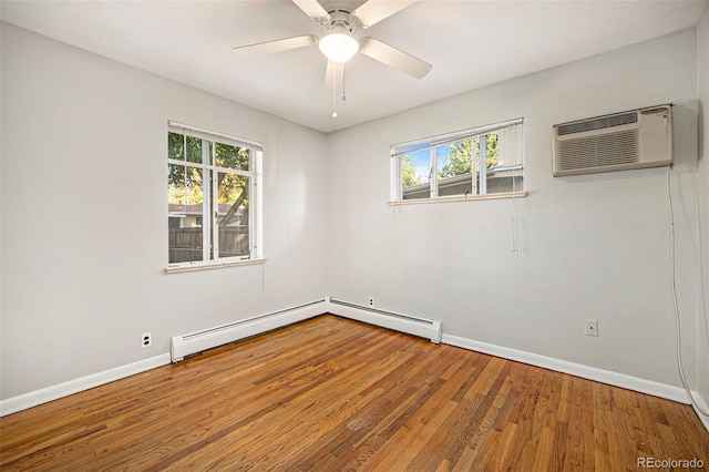 unfurnished room with a wall mounted air conditioner, a baseboard heating unit, a wealth of natural light, and wood finished floors