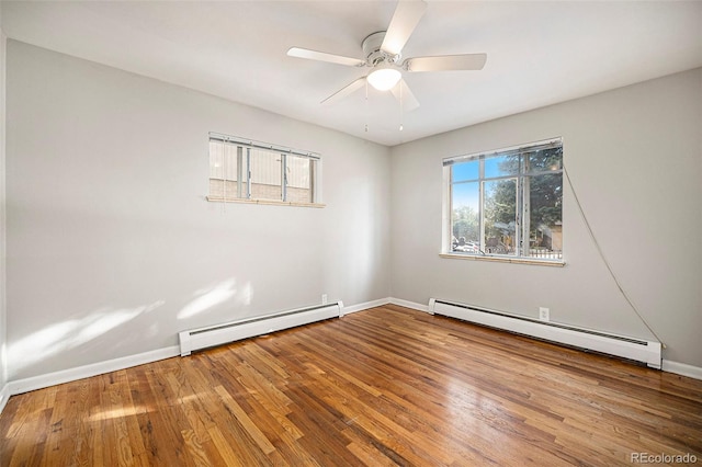 spare room featuring wood finished floors, baseboards, and a baseboard radiator