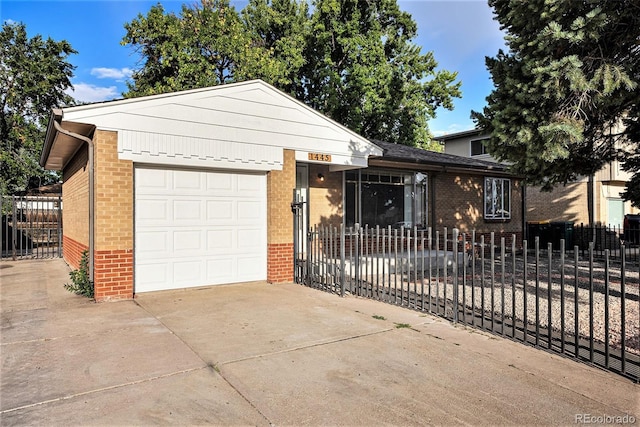 single story home featuring brick siding, a garage, driveway, and a fenced front yard