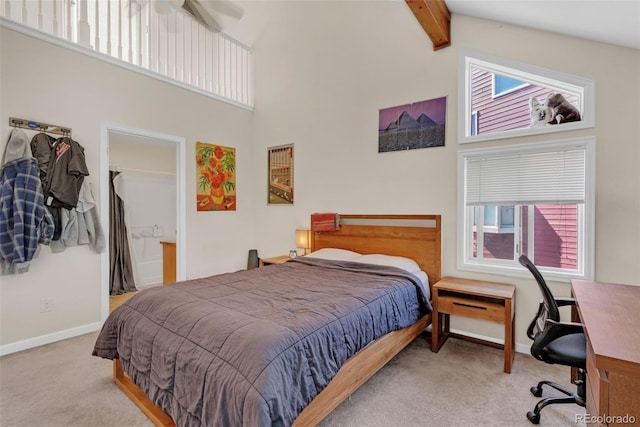 carpeted bedroom featuring beam ceiling, a high ceiling, and baseboards