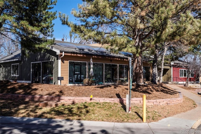 view of front facade featuring roof mounted solar panels