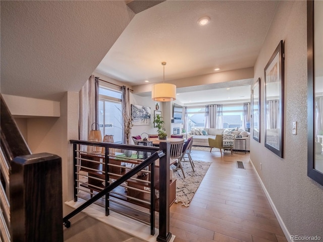 dining room with recessed lighting, a textured wall, a textured ceiling, wood finished floors, and baseboards