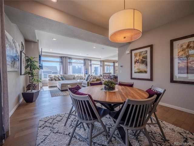 dining space with baseboards, wood finished floors, and a healthy amount of sunlight