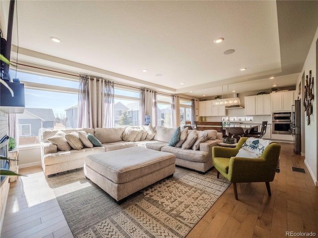 living room featuring baseboards, wood finished floors, and recessed lighting