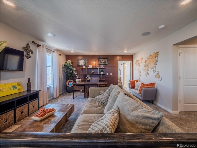 living room featuring recessed lighting, light carpet, a textured ceiling, and baseboards