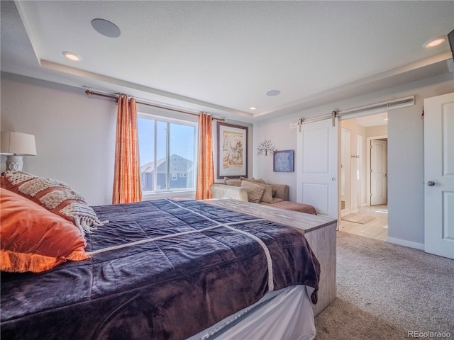 bedroom with light carpet, a barn door, baseboards, and recessed lighting