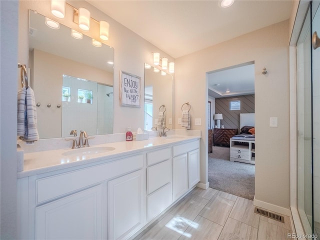 ensuite bathroom with ensuite bathroom, double vanity, a sink, and visible vents