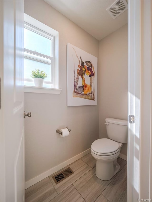 bathroom featuring baseboards, visible vents, and toilet