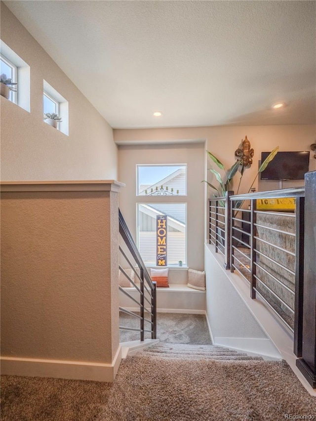 stairs with carpet, plenty of natural light, and baseboards