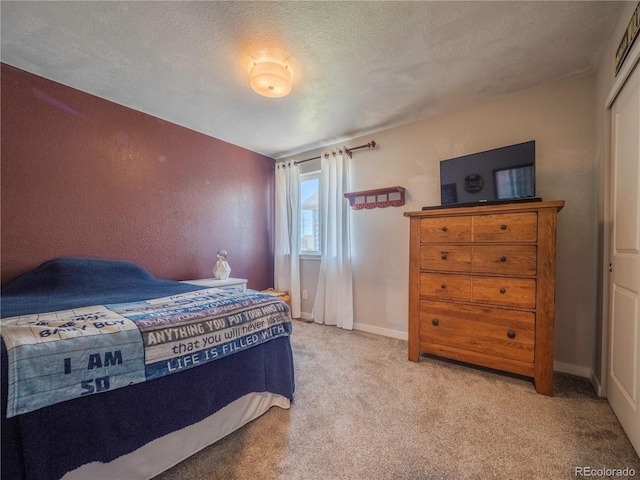 bedroom featuring carpet floors, a textured ceiling, and baseboards