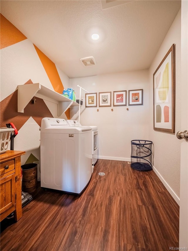 laundry area with dark wood-style flooring, visible vents, washing machine and dryer, laundry area, and baseboards