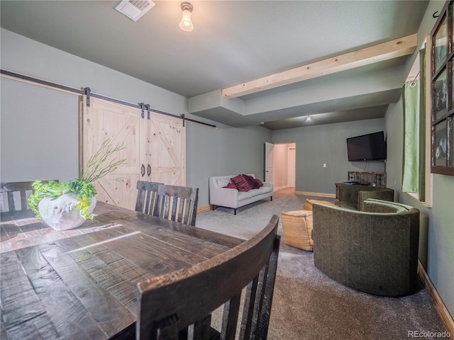 interior space with beam ceiling, visible vents, a barn door, carpet flooring, and baseboards