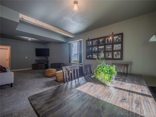 carpeted dining space with baseboards and beam ceiling