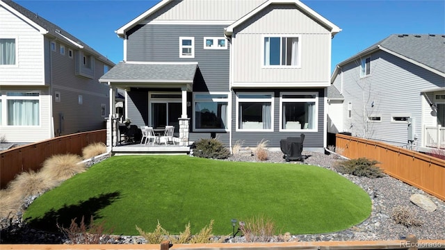 back of property featuring board and batten siding, a fenced backyard, and a lawn