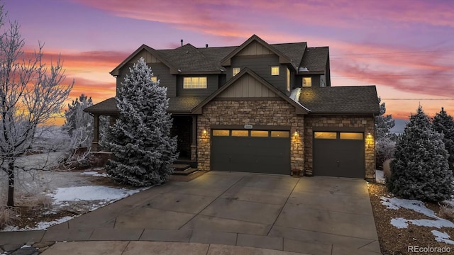 craftsman-style house with a shingled roof, an attached garage, board and batten siding, stone siding, and driveway