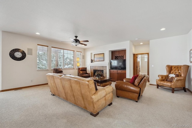 living area with recessed lighting, baseboards, a tiled fireplace, and light colored carpet