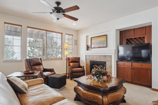 living room with light carpet, ceiling fan, a tiled fireplace, and recessed lighting