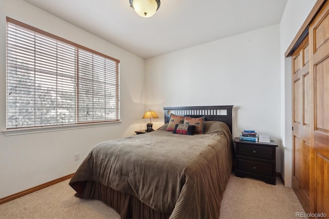 bedroom with light carpet and baseboards