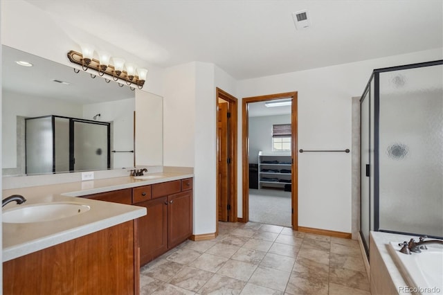 bathroom featuring a bath, a stall shower, double vanity, and a sink