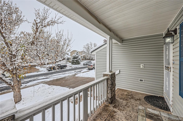 view of snow covered back of property