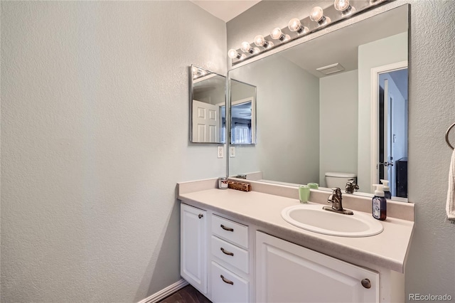 bathroom featuring vanity and toilet