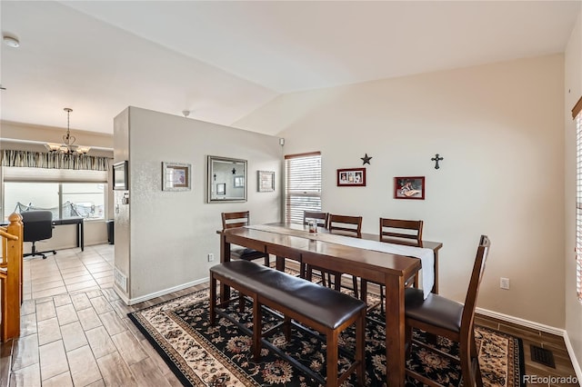 dining area with vaulted ceiling, a wealth of natural light, and a notable chandelier