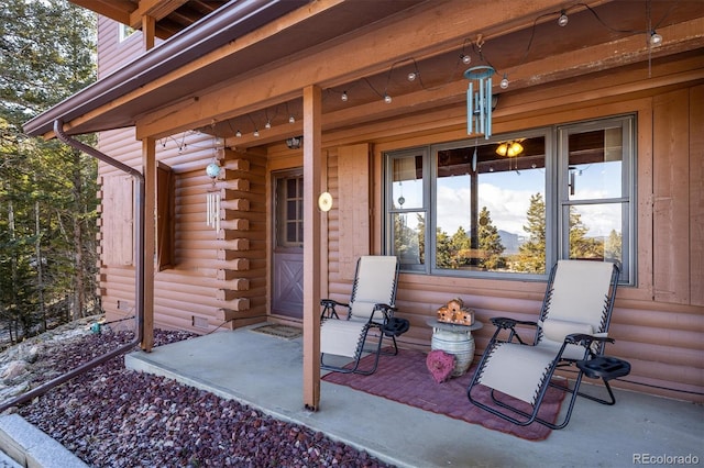 property entrance with covered porch and log exterior