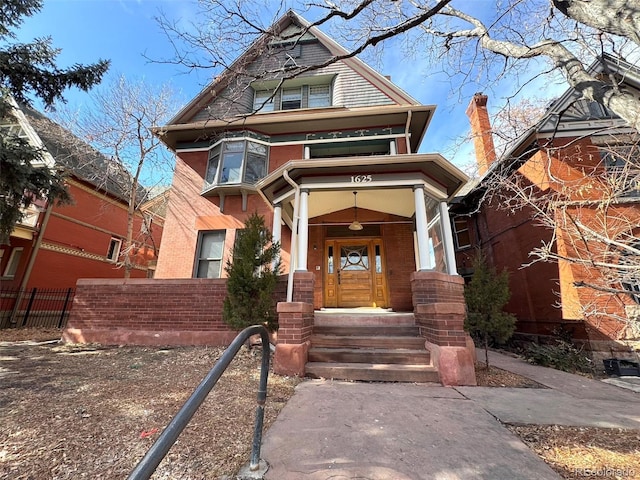 victorian home with fence and brick siding