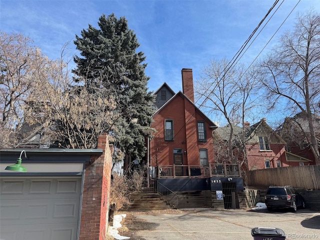 1625 N Downing St, Denver, CO 80218 - view of home's exterior with brick siding, fence, a garage, and a chimney