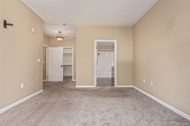 8427 S Hoyt Way Unit 107, Littleton, CO 80128 - unfurnished bedroom featuring carpet flooring, a walk in closet, ensuite bathroom, and a closet