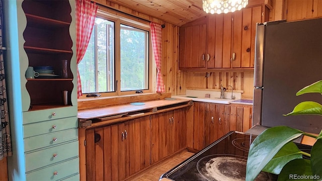 256 Fisk Fenner Rd, Allenspark, CO 80510 - kitchen with freestanding refrigerator, brown cabinetry, light countertops, light wood-style flooring, and open shelves