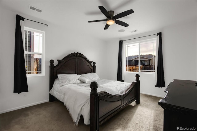 carpeted bedroom with multiple windows, baseboards, and visible vents