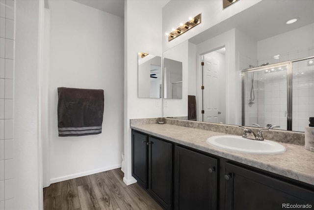 bathroom featuring a shower with door, vanity, and hardwood / wood-style floors