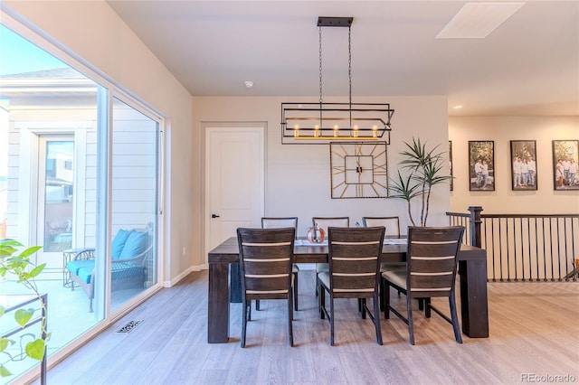 dining space featuring a wealth of natural light, hardwood / wood-style floors, and a notable chandelier