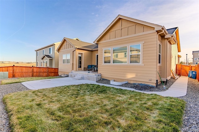 back of house featuring a lawn and a patio