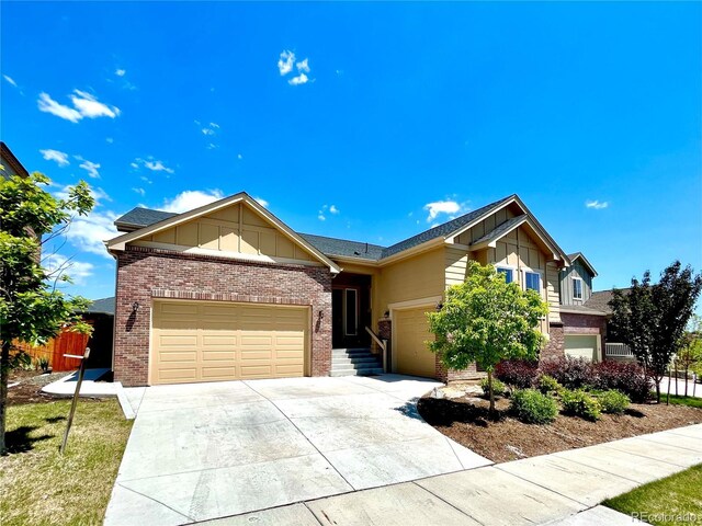 425 W 128th Dr, Westminster, CO 80234 - view of front of house with board and batten siding, driveway, brick siding, and an attached garage