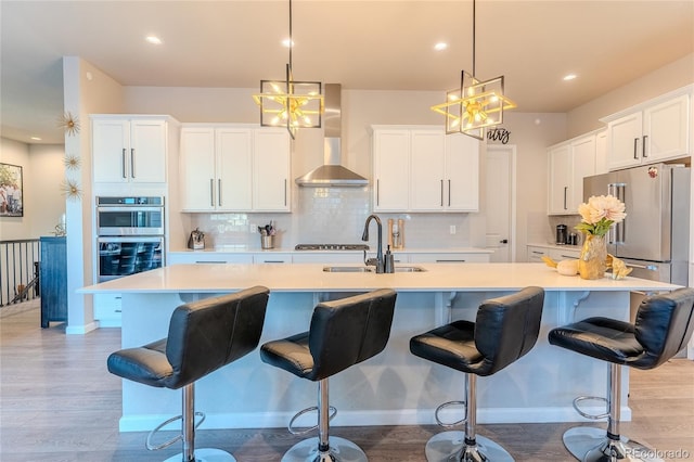 425 W 128th Dr, Westminster, CO 80234 - kitchen with wall chimney exhaust hood, a sink, stainless steel appliances, a center island with sink, and light countertops
