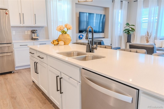 425 W 128th Dr, Westminster, CO 80234 - kitchen with stainless steel appliances, a sink, light countertops, white cabinets, and backsplash