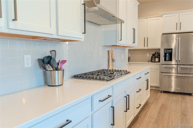 425 W 128th Dr, Westminster, CO 80234 - kitchen with stainless steel appliances, wall chimney exhaust hood, light countertops, and white cabinetry