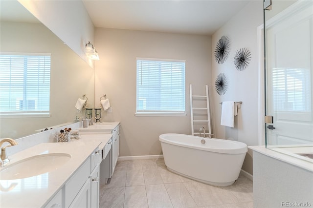 425 W 128th Dr, Westminster, CO 80234 - full bath with double vanity, a freestanding bath, plenty of natural light, and baseboards