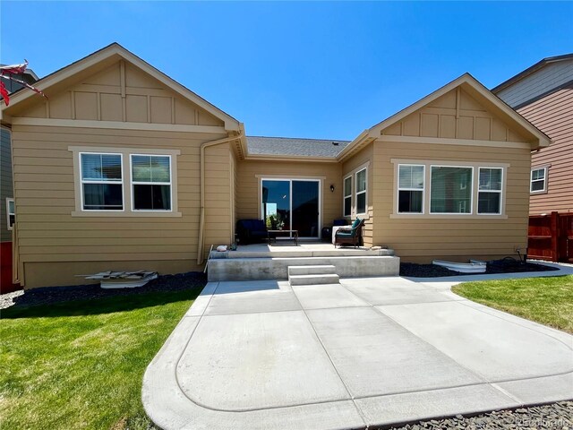 425 W 128th Dr, Westminster, CO 80234 - back of property featuring a patio, a lawn, board and batten siding, and roof with shingles